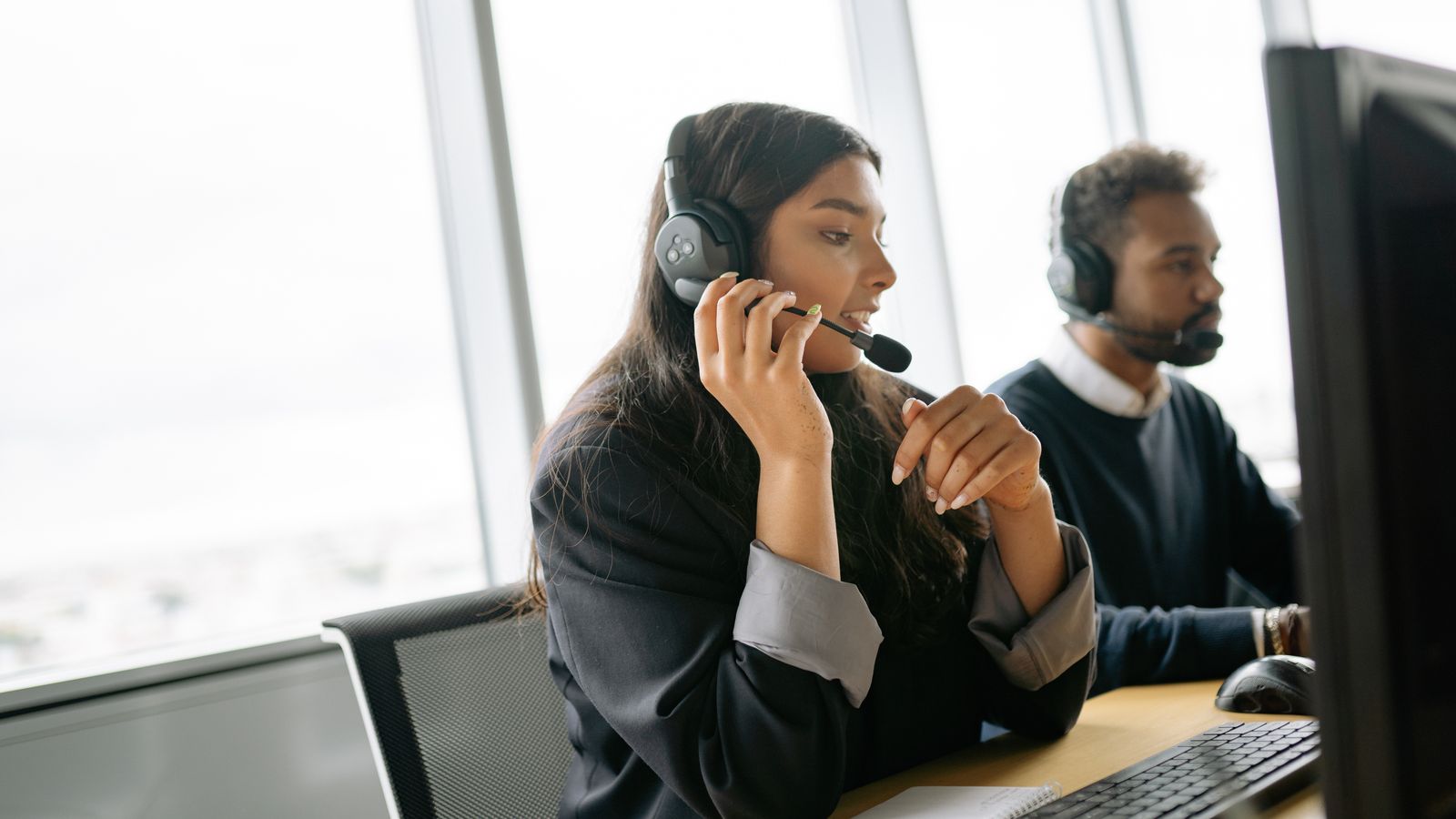 Two call center agents handling calls with headsets